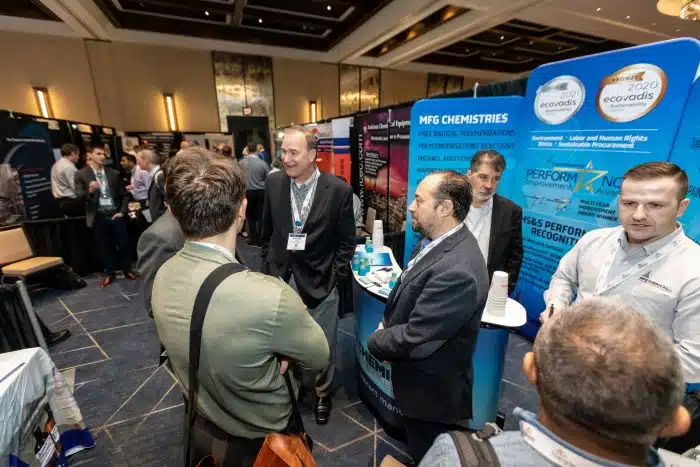 people discussing stainless steel drums at a pharma tradeshow