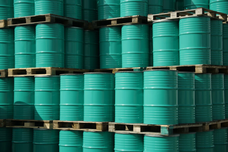 stack of teal stainless steel drums on pallets